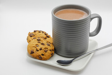cookies with chocolate chips and a cup with a hot drink on white background