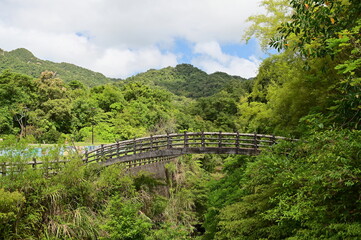 A cement arch bridge located beside a hiking trail in Pingxi District, New Taipei City, Taiwan. Captured on a sunny day under blue skies, this scenic spot complements the area's natural beauty.