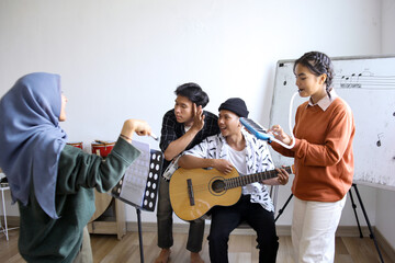 Group Of Diversity Asian Students Singing And Playing Musical Instruments Together