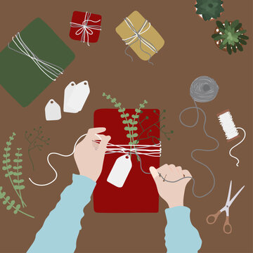 Envoltura de regalo para navidad sobre mesa con plantas y materiales