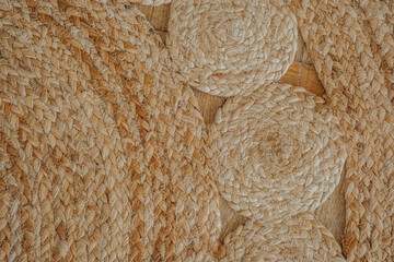 Natural woven texture of braided straw mat on wooden floor showcasing craftsmanship