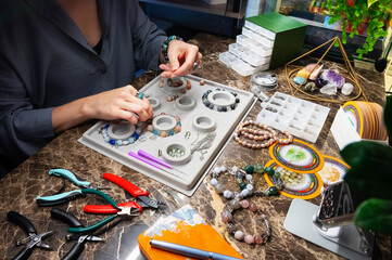 Handmade jewelry making, female hobby. Woman creating bracelet at home workshop. Fashion,...