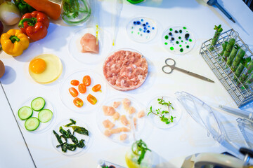 A detailed research concept in laboratory table setting, focused on food ingredients vegetables and meat. Test tubes, microscopes, lab equipment used to analyze nutritional extracts and vitamins.