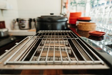 Dirty smokeless gas roaster made of stainless steel with a bokeh background