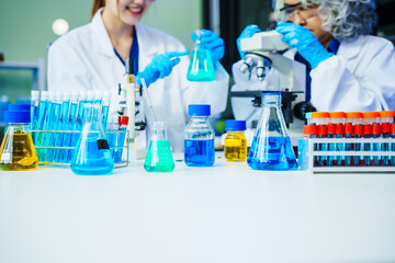 A reliable middle-aged Asian male researcher collaborates with experienced gray-haired elderly Asian female nutritionist in laboratory, food ingredients, extracts, their impact on nutrition health.