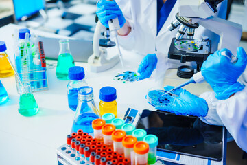 Fototapeta premium A reliable middle-aged Asian male researcher collaborates with experienced gray-haired elderly Asian female nutritionist in laboratory, food ingredients, extracts, their impact on nutrition health.