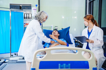 A middle-aged man lies bedridden on hospital bed, closely monitored by an old Asian woman doctor...
