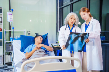 A middle-aged man lies bedridden on hospital bed, closely monitored by an old Asian woman doctor...