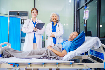 A middle-aged man lies bedridden on hospital bed, closely monitored by an old Asian woman doctor...