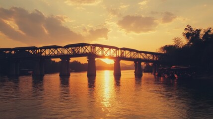 The picturesque view of the sunset behind the Mon Bridge, casting a golden glow.