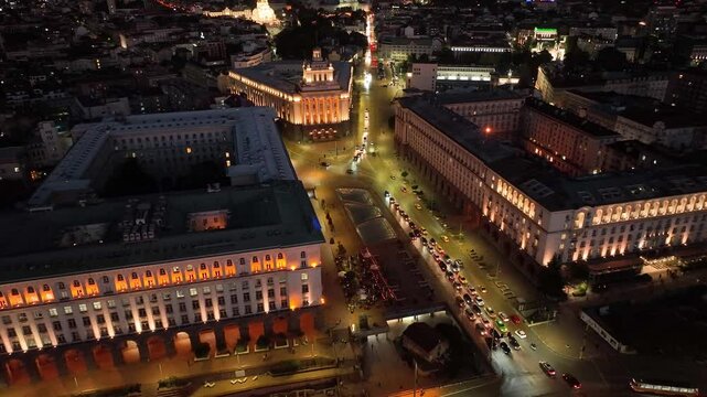 4K Aerial night view of capital of Bulgaria Sofia. Three architectural and iconic buildings of the communist era. Council of Ministers, Presidency and Party home Current Parliament building. Backward