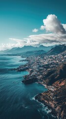 A stunning aerial view of a coastal city surrounded by mountains and turquoise waters under a bright blue sky.