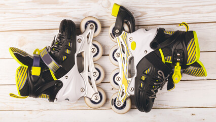 Stylish roller skates on blue background, top view. Inline skates on wooden background, extreme...