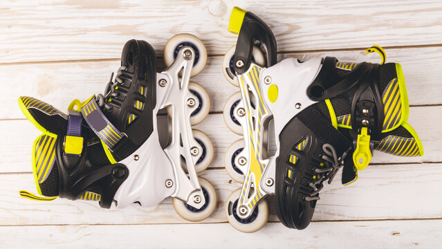 Stylish roller skates on blue background, top view. Inline skates on wooden background, extreme sports background