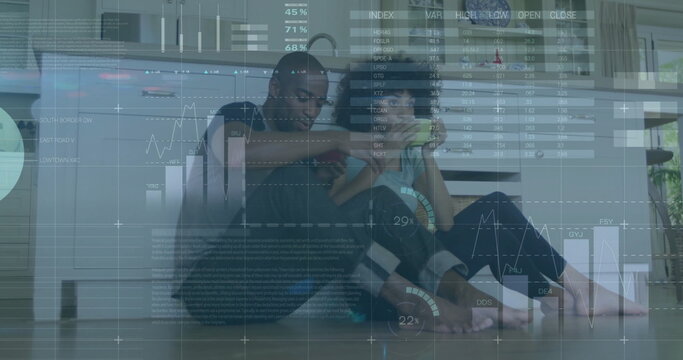 Image of data processing over diverse couple sitting on kitchen floor drinking tea