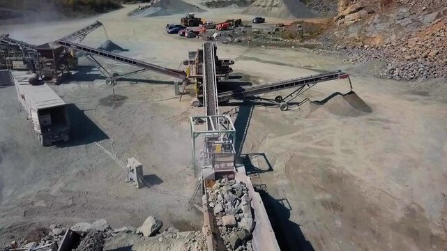 Rocks being passed through a series of rock crushing machines in huge gravel pit rock quarry