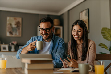 Happy family couple managing household budget, planning investment, analyzing paper utility bills,...