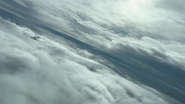 POV flying between layers of stratus clouds with the sun veiled by the clouds after a left turn. 4K 60FPS