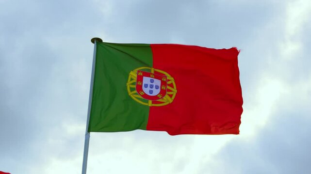 Portugal Portuguese Bandeira das Quinas Flag Waving in Wind in Slow Motion with Sunny Blue Sky Clouds Background. Patriotic, Nationalistic Concept Footage 4K