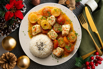 White fish stew with leeks and cherry tomatoes served with rice. Top view table with Christmas decoration.
