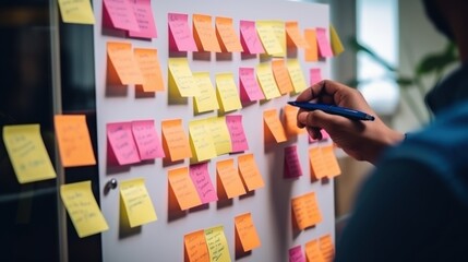 Person organizing colorful sticky notes, representing collaborative effort and dynamic project management in a vibrant office atmosphere.