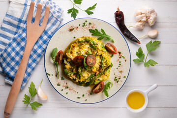 Scrambled organic chicken eggs with green asparagus and tomato. Top view table with  decoration.