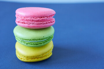 Colorful macaroons on blue background. Selective focus.