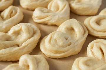 Raw buns on a baking sheet, close-up.