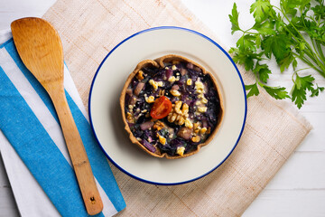 Individual vegan quiche with vegetables and red cabbage. Top view table with  decoration.