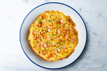 Individual quiche with vegetables and crab surimi. Top view table with decoration.