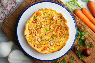 Individual quiche with vegetables and crab surimi. Top view table with decoration.