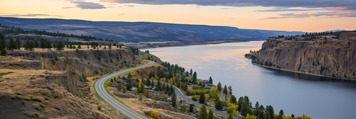 Scenic river view with winding road against mountains at sunset in rural landscape