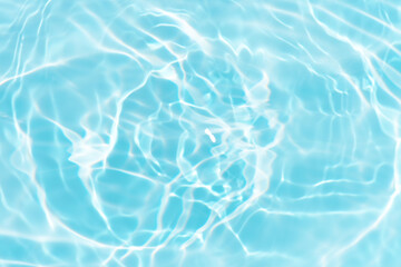 Blue water with ripples on the surface. Defocus blurred transparent blue colored clear calm water surface texture with splashes and bubbles. Water waves with shining pattern texture background.