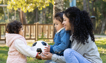 Side view of happy hispanic family with mother and her lovely children enjoying a weekend oudoors...