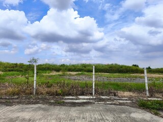 Land for sales concept. Landscape of empty land plot for development, and beautiful blue sky. 