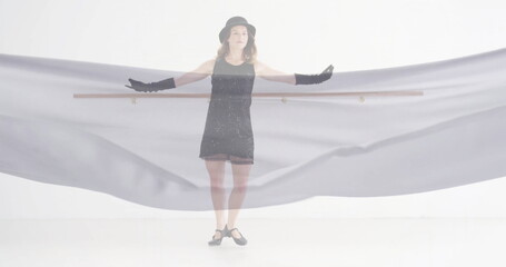 Image of caucasian woman dancing over floating cloth on white background