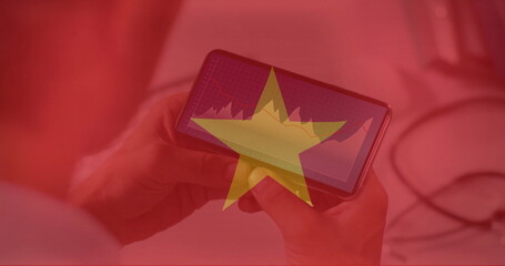 Image of flag of vietnam over caucasian businessman using smartphone