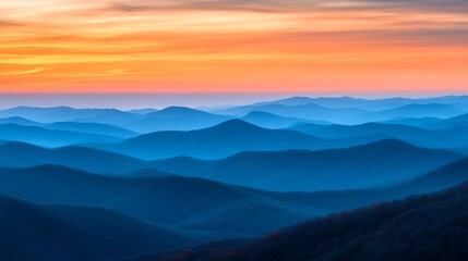 Fototapeta premium Layers of misty mountains under a vibrant sunset sky, capturing nature's beauty at twilight in a serene landscape