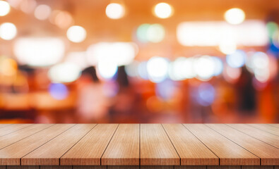 Empty wooden table top with lights bokeh on blur restaurant background.