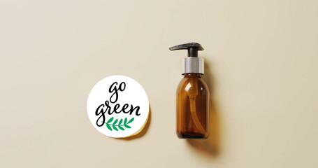 Image of go green text and leaf logo over lemon slice and beauty oil pump bottle