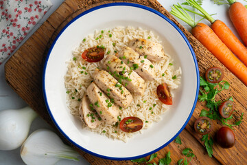 Baked chicken with thyme aroma on white rice. Top view table with decoration.