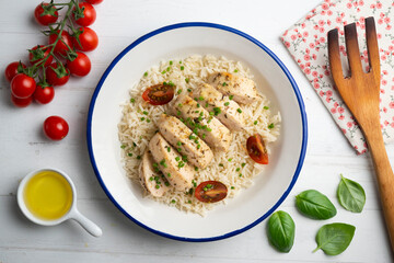Baked chicken with thyme aroma on white rice. Top view table with decoration.