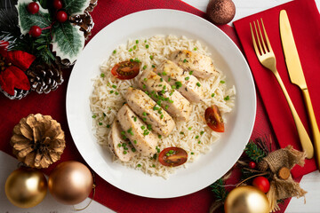 Baked chicken with thyme aroma on white rice. Top view table with Christmas decoration.