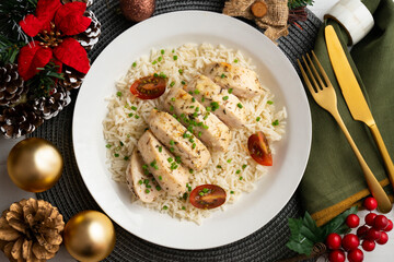 Baked chicken with thyme aroma on white rice. Top view table with Christmas decoration.