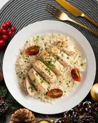 Baked chicken with thyme aroma on white rice. Top view table with Christmas decoration.
