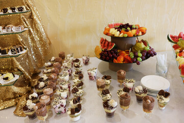 Cakes, mousses and fruits on the buffet table.