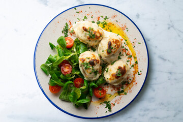 Backed Stuffed eggs au gratin with bechamel sauce. Top view table with  decoration.