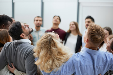 Team of young people hugging in the office.