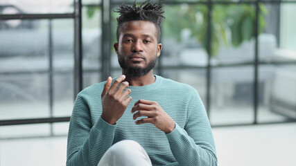 African American man in green sweater looking at camera