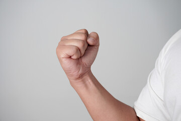 Male clenched fist, throwing punch, over grey